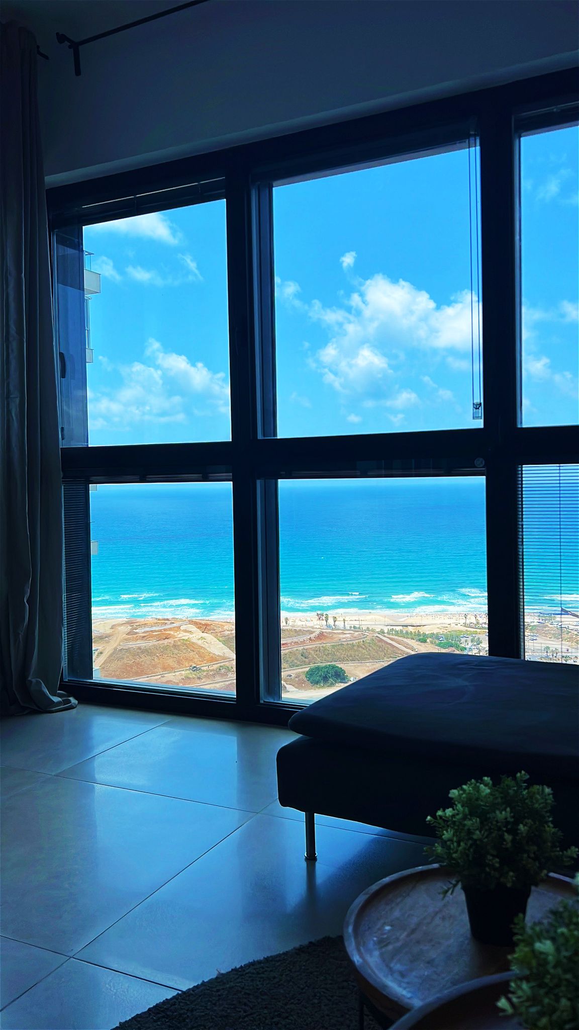 סלון מרווח עם ריצוף מלוטש ונוף לים בפרויקט מגורים